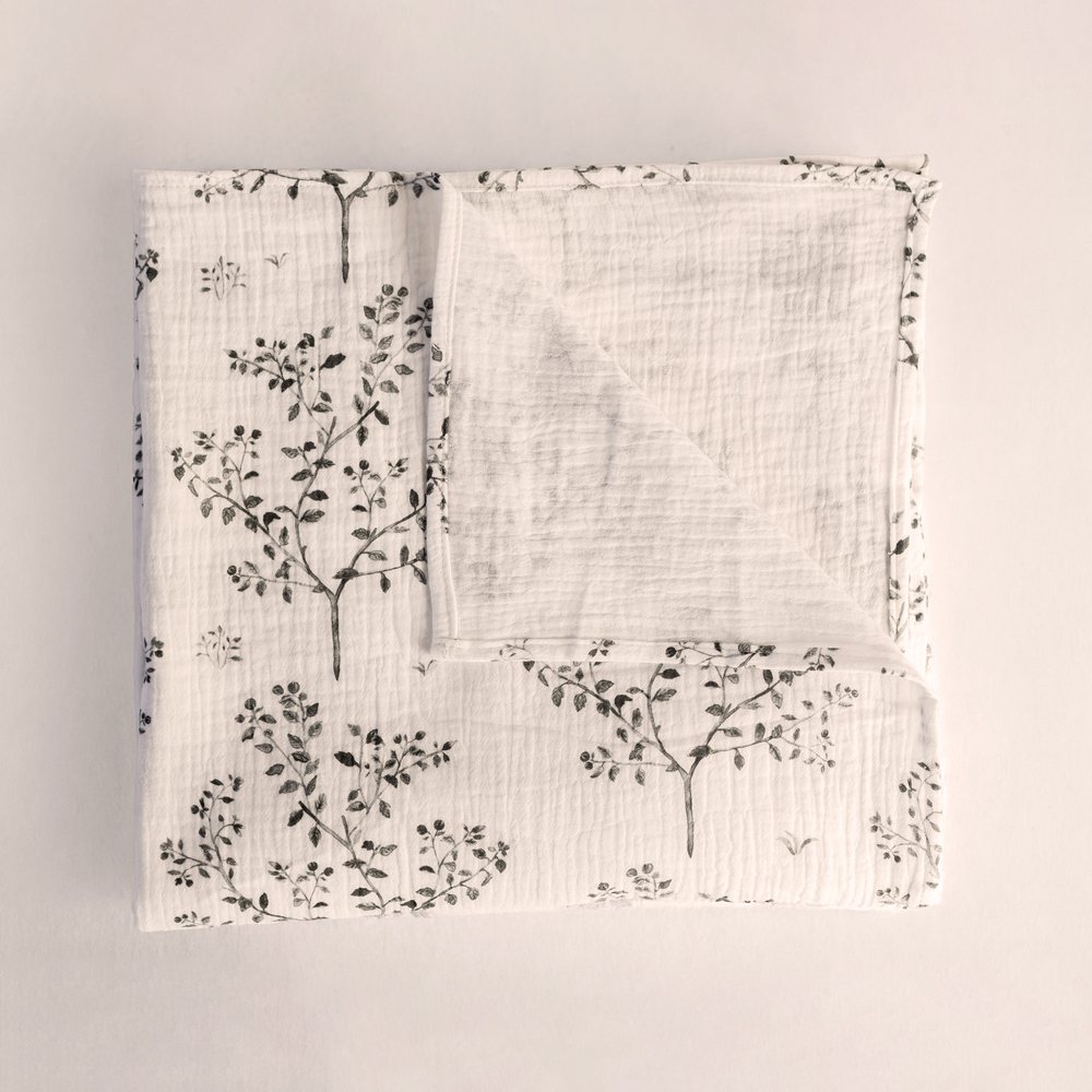 Snowberry muslin swaddle folded flat, inky grey stems on white